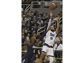 Nevada forward Caleb Martin (10) shoots over Akron's Jimond Ivey (0) in the first half of an NCAA college basketball game in Reno, Nev., Saturday, Dec. 22, 2018.