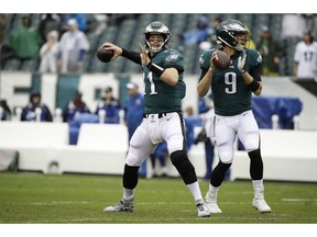 FILE - In this Sept. 23, 2018, file photo, Philadelphia Eagles quarterback Carson Wentz (11) and quarterback Nick Foles (9) throw before an NFL football game against the Indianapolis Colts, in Philadelphia.  Eagles coach Doug Pederson says Carson Wentz has a stress fracture in his back and is questionable to play Sunday night, Dec. 16 against the Rams in Los Angeles.