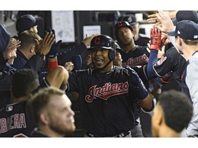FILE - In this Sept. 26, 2018, file photo, Cleveland Indians' Edwin Encarnacion, center, celebrates in the dugout after he hit a three run home run against the Chicago White Sox during the fourth inning of a baseball game in Chicago. Encarnacion has been traded to Seattle and first baseman Carlos Santana has returned to the Indians in a three-team deal that also involved Tampa Bay. The Rays got infielder Yandy Diaz and minor league right-hander Cole Slusser from Cleveland. The Indians also acquired first baseman Jake Bauers. The swap came Thursday, Dec. 13, 2018, at the close of the winter meetings.