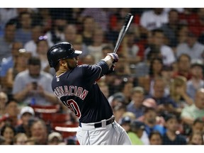 FILE - In this Aug. 22, 2018, file photo, Cleveland Indians' Edwin Encarnacion follows through on his second two-run home run of the night, during the fifth inning of a baseball game against the Boston Red Sox, in Boston. Edwin Encarnacion has been traded to Seattle and first baseman Carlos Santana has returned to the Indians in a three-team deal that also involved Tampa Bay. The Rays got infielder Yandy Diaz and minor league right-hander Cole Slusser from Cleveland. The Indians also acquired first baseman Jake Bauers. The swap came Thursday, Dec. 13, 2018,  at the close of the winter meetings.