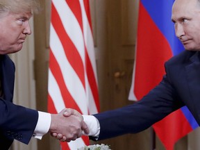 FILE - In this Monday, July 16, 2018 file photo, U.S. President Donald Trump, left, and Russian President Vladimir Putin, right, shake hand at the beginning of a meeting at the Presidential Palace in Helsinki, Finland. Throughout 2018, special cnvestigator Robert Mueller's team investigated whether Trump's campaign colluded with Russia ahead of the 2016 election and whether the president obstructed the investigation.