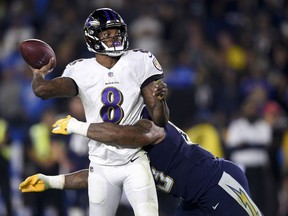 FILE - In this Dec. 22, 2018, file photo, Baltimore Ravens quarterback Lamar Jackson passes under pressure from Los Angeles Chargers defensive tackle Darius Philon during the first half in an NFL football game in Carson, Calif. From Baker Mayfield at the top of the first round to Jackson at the bottom, rookie quarterbacks had an impact, one way or another, in their NFL debuts.