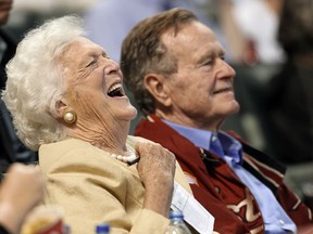 FILE - In this April 18, 2009, file photo, Barbara Bush laughs alongside former President George H.W. Bush, right, as they attend a baseball game in Houston. Barbara Bush, the snowy-haired first lady whose plainspoken manner and utter lack of pretense made her more popular at times than her husband, President George H.W. Bush, died Tuesday, April 17, 2018. She was 92.