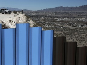 FILE - In this Jan. 25, 2017, file photo, an agent from the border patrol, observes near the Mexico-US border fence, on the Mexican side, separating the towns of Anapra, Mexico and Sunland Park, N.M. An 8-year-old boy from Guatemala died in government custody early Tuesday, Dec. 25, 2018, U.S. immigration authorities said.