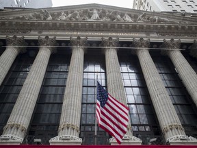 FILE - In this Nov. 20, 2018, file photo an American flag flies outside New York Stock Exchange. Stocks are opening solidly higher on Wall Street as the market claims back some of the ground it lost in steep drops over the previous two days. Technology and industrial stocks were among the biggest winners in early trading Tuesday, Dec. 18.