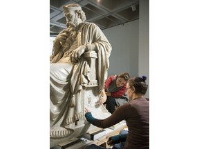 In this Dec. 12, 2018 photo, objects conservators Marianne Schmeisser, left, and Corey Riley clean the base of the statue "Saul under the Influence of the Evil Spirit" at the North Carolina Museum of Art, in Raleigh, N.C. The museum bought the sculpture, carved in 1865 by American William Wetmore Story, from Rendcomb College, a private boarding school in England. The students would dress up Saul at Christmas as characters such as Santa Claus and Gandolf from "Lord of the Rings" so the conservators are finding things such as black nail paint and glitter in the crevices of the clothing on the statute.