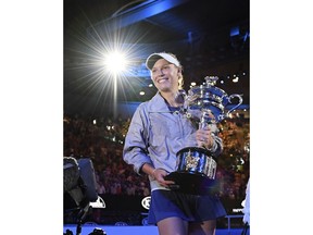 FILE - In this Jan. 27, 2018, file photo, Denmark's Caroline Wozniacki carries her trophy around Rod Laver Arena after defeating Romania's Simona Halep in the women's singles final at the Australian Open tennis championships in Melbourne, Australia.