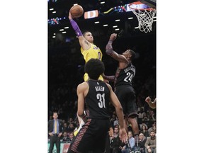 Los Angeles Lakers' Kyle Kuzma (0) dunks the ball in front of Brooklyn Nets' Rondae Hollis-Jefferson (24) and Jarrett Allen (31) during the first half of an NBA basketball game Tuesday, Dec. 18, 2018, in New York.