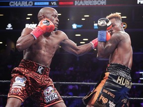 Tony Harrison, left, punches Jermell Charlo during the first round of the WBC super welterweight championship boxing match Saturday, Dec. 22, 2018, in New York. Harrison won the fight.