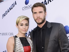FILE - In this Aug. 8, 2013, file photo, actor Liam Hemsworth and singer and actress Miley Cyrus arrive on the red carpet at the US premiere of the feature film "Paranoia" at the DGA Theatre in Los Angeles. Cyrus and Hemsworth have tied the knot amid reports the couple got married in a secret wedding ceremony. Cyrus posted three black-and-white photos of her and Hemsworth on the singer's Instagram and Twitter accounts on Wednesday, Dec. 26, 2018.