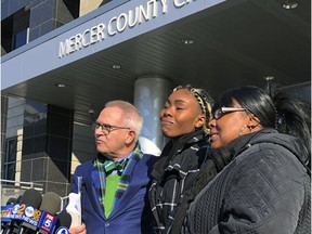 FILE - In this Dec. 12, 2018, file photo, Jazmine Headley, center, joins attorney Brian Neary and her mother, Jacqueline Jenkins, outside a courthouse in Trenton, N.J., after she accepted a deal to enter a pretrial intervention program related to credit card theft charges she faced. Headley, who had her toddler yanked from her arms by New York police in a widely seen video said in an interview published on Sunday that she went into "defense mode."