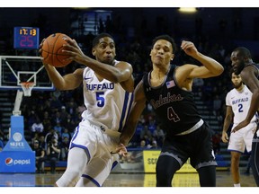 Buffalo guard CJ Massinburg (5) drives past Southern Illinois guard Eric McGill (4) during the first half of an NCAA college Basketball game, Saturday, Dec. 15, 2018, in Buffalo N.Y.