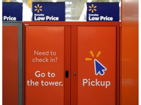 FILE- In this Nov. 9, 2018, file photo S\signs directing customers to pickup orders placed online are shown at a Walmart Supercenter  in Houston. Plenty of major retailers are offering easier ways for customers to pick up items ordered online beyond the service desk. Walmart is adding lockers and big giant kiosks that spit out online orders.