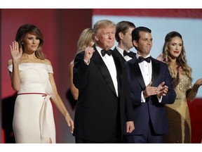 FILE - In this Jan. 20, 2017, file photo President Donald Trump, center, raises his fist alongside first lady Melania Trump, left, and son Donald Trump, Jr., after dancing at the Liberty Ball following his inauguration in Washington. Federal prosecutors are reportedly investigating the finances of Trump's inaugural committee and whether foreigners made illegal contributions to its events.