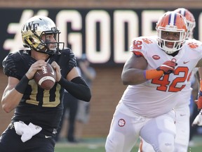 File-This Oct. 6, 2018, file photo shows Wake Forest's Sam Hartman (10) looking to pass under pressure from Clemson's Christian Wilkins (42) during the first half of an NCAA college football game in Charlotte, N.C. Wilkins is here to put a smile on your face, whether you like it or not. For four seasons, Wilkins has been bringing the jokes, zingers and sneaky pinches on the bottom at Clemson. The 300-pound All-America defensive tackle famously celebrated the Tigers' 2016 national championship with a split and flashed a Heisman pose after a touchdown run this season.
