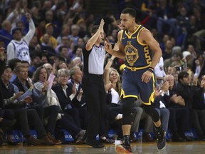 Golden State Warriors' Stephen Curry celebrates after scoring his 15,000th career NBA point against the Memphis Grizzlies during the first half of an NBA basketball game Monday, Dec. 17, 2018, in Oakland, Calif.