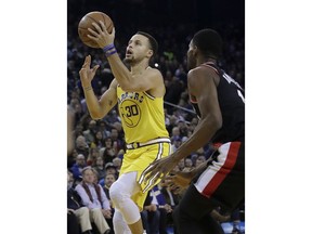 Golden State Warriors guard Stephen Curry (30) shoots next to Portland Trail Blazers forward Maurice Harkless during the first half of an NBA basketball game in Oakland, Calif., Thursday, Dec. 27, 2018.