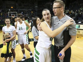 Oregon's Sabrina Ionescu, center left, gets a hug from acting head coach Mark Campbell, right, after their win over Air Force in an NCAA college basketball game, Thursday Dec. 20, 2018, in Eugene, Ore. Head coach Kelly Graves had to sit out the game as part of an NCAA suspension.
