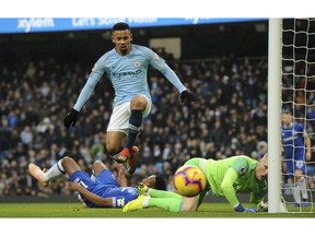 Manchester City's Gabriel Jesus, center, jumps over Everton's Jordan Pickford, right, during the English Premier League soccer match between Manchester City and Everton at Etihad stadium in Manchester, England, Saturday, Dec. 15, 2018.