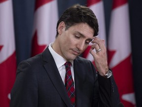 Canadian Prime Minister Justin Trudeau scratches his forehead as he listens to a question during an end of session news conference in Ottawa, Wednesday, Dec. 19, 2018.