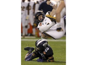 California quarterback Chase Garbers, top, gets upended by TCU safety Vernon Scott (26) during the first half of the Cheez-It Bowl NCAA college football game Wednesday, Dec. 26, 2018, in Phoenix.