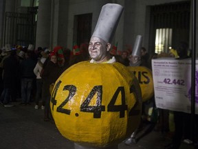 A man dressed as a lottery ball waits to enter Madrid's Teatro Real opera house for the Spanish Christmas Lottery draw in Madrid, Spain, Saturday, Dec. 22, 2018. Holders of the ticket number 03347 struck it rich Saturday when they won the top prize in Spain's bumper Christmas lottery. The lottery, known as El Gordo, or The Fat One, dished out 2.4 billion euros ($2.7 billion) in prize-money this year.