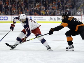 Columbus Blue Jackets' Nick Foligno (71) tries to keep Philadelphia Flyers' Radko Gudas (3) away from the puck during the first period of an NHL hockey game, Saturday, Dec. 22, 2018, in Philadelphia.