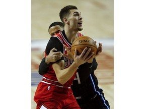 Chicago Bulls' Zach LaVine, front, is fouled by Orlando Magic's D.J. Augustin in the first half of their regular-season NBA basketball game in Mexico City, Thursday, Dec. 13, 2018.