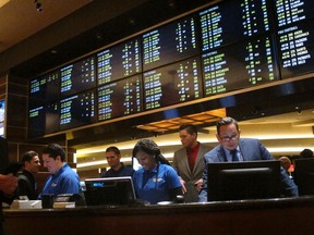 This Oct. 25, 2018 photo shows employees at the new sports book at the Tropicana casino in Atlantic City N.J., preparing to take bets moments before it opened. On Dec. 18, 2018, Canadian firm theScore announced it will enter New Jersey's sports betting market next year, and the NBA and FanDuel announced a gambling agreement.