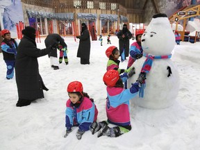 FILE - In this March 9, 2018 file photo, children play by snow at the "Snow City" in the Othaim Mall, in Riyadh, Saudi Arabia. King Salman has extended monthly allowances for government employees, military personnel, pensioners, social security recipients and students into next year. The announcement, carried by the Saudi Press Agency on Tuesday, Dec. 18, 2018, comes on the same day the kingdom's 2019 budget is scheduled to be unveiled.