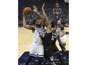 Minnesota Timberwolves center Karl-Anthony Towns, left, goes to the basket against Sacramento Kings center Willie Cauley-Stein during the first quarter of an NBA basketball game, Wednesday, Dec. 12, 2018, in Sacramento, Calif.