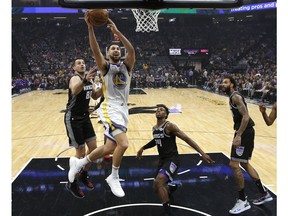 Golden State Warriors guard Klay Thompson, second from left, goes to the basket against Sacramento Kings' Nemanja Bjelica, left, Buddy Hield, third from left and Willie Cauley-Stein, right, during the first half of an NBA basketball game Friday, Dec. 14, 2018, in Sacramento, Calif.