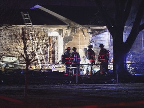 In this Dec. 25, 2018 photo, first responders survey the scene where a plane crashed into a home in Sioux Falls, S.D. Two people died when the single-engine airplane crashed and caught fire in a residential neighborhood in Sioux Falls, leading to the evacuation of four homes, police said Wednesday.