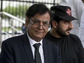 In this Oct. 8, 2018 file photo, Saiful Malook, left, defense lawyer for Asia Bibi, a Pakistani Christian woman convicted of blasphemy and later acquitted on appeal, leaves the Supreme court with a bodyguard, in Islamabad, Pakistan.