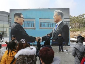 In this Dec. 13, 2018, file photo, people take pictures of an image of North Korean leader Kim Jong Un, left, and South Korean President Moon Jae-in displayed at a park near the presidential Blue House in Seoul, South Korea. South Korea says Sunday, Dec. 30, 2018, North Korean leader Kim Jong Un has sent a letter to South Korean President Moon Jae-in calling for more talks between the leaders in the new year.