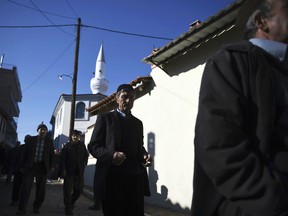 In this Friday, Dec. 8, 2017 file photo, pilgrims walk outside Kirmahalle Cammi mosque in the northeastern Greek town of Komotini. Lawmakers in Greece are set to limit powers of Islamic courts which operate in a border region of the town of Komotini that is home to a 100,000-strong Muslim minority, following a European court challenge.