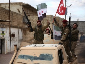 Turkish-backed Syrian fighters raise Turkish and opposition flags in the north of Aleppo province before heading to the Kurdish-controlled town of Manbij.