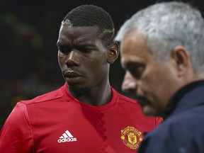 FILE - In this Thursday, Sept. 29, 2016 file photo Manchester United's manager Jose Mourinho, right, with Manchester United's Paul Pogba just prior to the start of Europa League group A soccer match between Manchester United and Zorya Luhansk at Old Trafford, Manchester, England. Manchester United says Jose Mourinho has left the Premier League club with immediate effect. The decision was announced Tuesday Dec.18, 2018, two days after a 3-1 loss to Liverpool left United 19 points off the top of the Premier League after 17 games.