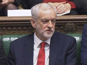 Labour leader Jeremy Corbyn says something under his breath after the British Prime Minister Theresa May likened Labour's attempt to table a no confidence motion in her to a pantomime, during the weekly Prime Minister's Questions in the House of Commons, London, Wednesday Dec. 19, 2018.  With 100 days until Britain leaves the European Union, the government was publishing long-awaited plans Wednesday for a post-Brexit immigration system that will end free movement of EU citizens to the U.K.