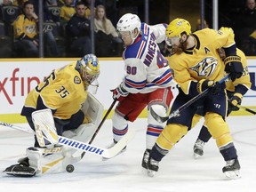 New York Rangers center Vladislav Namestnikov (90), of Russia, and Nashville Predators defenseman Ryan Ellis (4) reach for the rebound after Predators goaltender Pekka Rinne (35), of Finland, blocked a shot in the first period of an NHL hockey game Saturday, Dec. 29, 2018, in Nashville, Tenn.