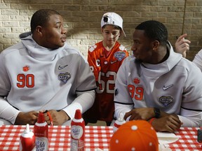 Clemson defensive tackle Dexter Lawrence, left, and defensive end Clelin Ferrell talk as honorary captain Layton Horner, center, stands by during a hospital visit at Texas Scottish Rite Hospital in Dallas, Thursday, Dec. 27, 2018. Clemson will play against Notre Dame in the Cotton Bowl on Saturday.