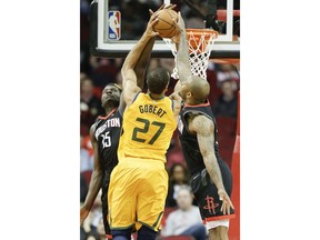 Utah Jazz center Rudy Gobert (27) drives to the basket as Houston Rockets center Clint Capela, left, and forward PJ Tucker defend during the first half of an NBA basketball game, Monday, Dec. 17, 2018, in Houston.