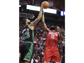 Boston Celtics forward Marcus Morris, left, blocks the shot of Houston Rockets guard James Harden during the first half of an NBA basketball game, Thursday, Dec. 27, 2018, in Houston.