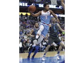 Sacramento Kings guard Yogi Ferrell (3) looks to pass past Dallas Mavericks defenders Dirk Nowitzki (41) of Germany and Jalen Brunson (13) during the first half of an NBA basketball game in Dallas, Sunday, Dec. 16, 2018.