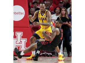 Houston guard Armoni Brooks (3) goes down onto the court after wrestling the ball from LSU guard Ja'vonte Smart (1) during the first half of an NCAA college basketball game Wednesday, Dec. 12, 2018, in Houston.