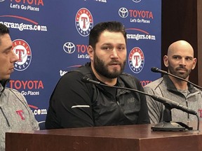 Newly signed Texas Rangers pitcher, Lance Lynn, center, responds to reporters questions as team general manager Jon Daniels, left, and manager Chris Woodward, right, look on in Arlington, Texas, Tuesday, Dec. 18, 2018.