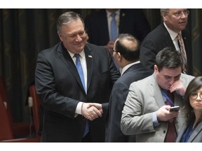 American Secretary of State Mike Pompeo, left, speaks to Kuwaiti Ambassador to the United Nations Mansour Ayyad Al-Otaibi during a Security Council meeting on Iran's compliance with the 2015 nuclear agreement, Wednesday, Dec. 12, 2018 at United Nations headquarters.