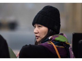 Huawei chief financial officer Meng Wanzhou, talks with a member of her private security detail after they went into the wrong building while arriving at a parole office, in Vancouver, on Wednesday December 12, 2018.