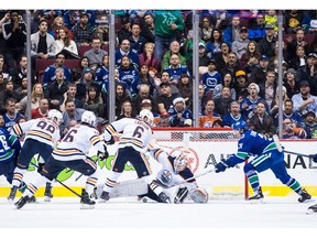 Edmonton Oilers goalie Mikko Koskinen, centre, of Finland, stops Vancouver Canucks' Loui Eriksson, right, of Sweden, as Edmonton's Jesse Puljujarvi (98), of Sweden, Jujhar Khaira (16) and Adam Larsson (6), of Sweden, defend during third period NHL hockey action in Vancouver on Sunday, Dec. 16, 2018.
