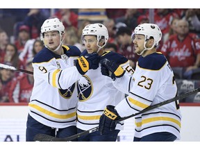 Buffalo Sabres center Jack Eichel (9) celebrates his goal with left wing Jeff Skinner, center, and center Sam Reinhart (23) during the first period of an NHL hockey game against the Washington Capitals, Saturday, Dec. 15, 2018, in Washington.